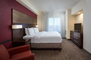 a hotel room with a large bed and a chair at Residence Inn by Marriott Philadelphia Airport in Philadelphia