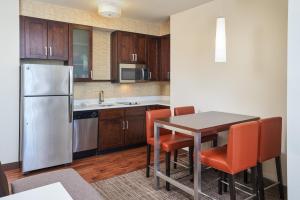 uma cozinha com uma mesa e um frigorífico em Residence Inn by Marriott Philadelphia Airport em Filadélfia