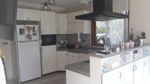 a kitchen with white cabinets and a refrigerator at Harvel Villa - RESIDENCE FOR FAMILY ONLY - 6 BEDROOMS 