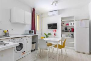 uma cozinha com electrodomésticos brancos e uma mesa e cadeiras em Apartamento céntrico y confortable em Madri