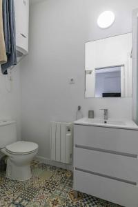 biała łazienka z toaletą i umywalką w obiekcie Apartamento céntrico y confortable w Madrycie