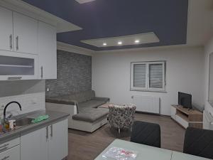 een keuken en een woonkamer met een bank en een tafel bij Apartman Knežević in Donja Varoš