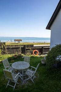 a table and chairs with the beach in the background at Historical beachhouse in Snekkersten in Snekkersten