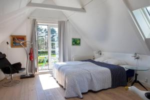 a bedroom with a bed and a table and a window at Historical beachhouse in Snekkersten in Snekkersten