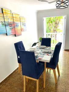 einen Esstisch mit vier blauen Stühlen, einem Tisch und einem Chairsktop in der Unterkunft Cómodo apto zona histórica Cgena in Cartagena de Indias
