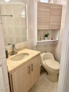 ein Badezimmer mit einem WC, einem Waschbecken und einem Spiegel in der Unterkunft Cómodo apto zona histórica Cgena in Cartagena de Indias