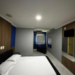Hotel Clima في سلفادور: غرفة نوم مع سرير أبيض كبير في غرفة
