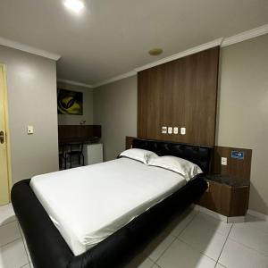 um quarto com uma grande cama branca num quarto em Hotel Clima em Salvador