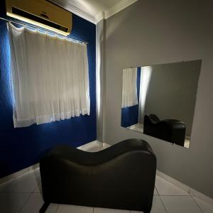 uma cadeira preta num quarto com um espelho em Hotel Clima em Salvador