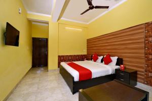 a hotel room with a bed and a tv at OYO Flagship Maira Residency in Dehradun