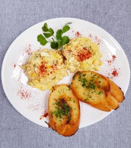 une assiette de nourriture avec des pommes de terre et des œufs sur une table dans l'établissement Ranczo siódmy koń, à Złoty Stok