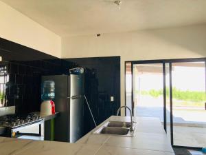 a kitchen with a stainless steel refrigerator and a sink at Casa la Noria in Parras de la Fuente