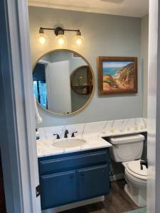 a bathroom with a sink and a toilet and a mirror at Relax @CercaDelPlaya: .7mi to the Beach! 4BR/2.5BA in San Diego