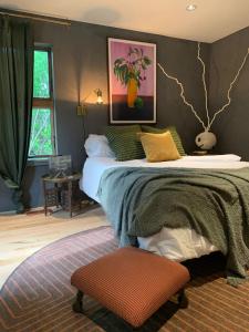 a bedroom with a large bed and a chair at The Trail in Adams - Berkshires' Art Hotel in Adams