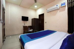 a bedroom with a bed and a tv in it at OYO 9808 Hotel Prem Sagar in Ludhiana
