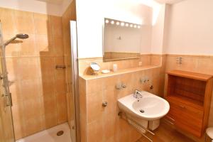 y baño con lavabo, ducha y espejo. en Villa Sola Bona, FW 2 en Zingst