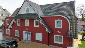 una casa roja con techo negro en Villa Sola Bona, FW 2 en Zingst