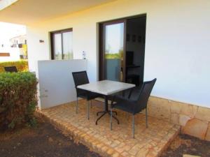a table and chairs sitting next to a building at Cozy 1 bed apartment with garden and pool view in Santa Maria