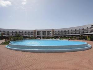 a large swimming pool in front of a building at Cozy 1 bed apartment with garden and pool view in Santa Maria