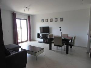 a living room with a table and a dining room at Cozy 1 bed apartment with garden and pool view in Santa Maria