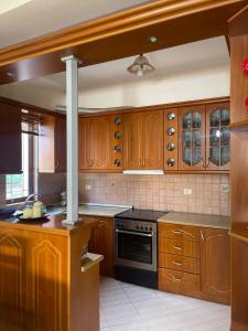 - une cuisine avec des placards en bois et une cuisinière dans l'établissement Green-Garden Apartmets, à Saranda