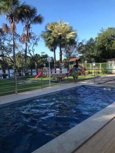 Ein Mädchen steht neben einem Pool in der Unterkunft Casa para Temporada Lençóis Ville in Barreirinhas