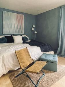 a bedroom with a bed with a chair and a couch at The Trail in Adams - Berkshires' Art Hotel in Adams