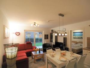 a living room with a red couch and a table at Villa Sola Bona, FW 2 in Zingst