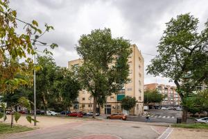 una calle con árboles y edificios en una ciudad en ARRIAGA ALTO- Coqueto duplex. Parking gratuito, en Madrid