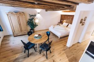 uma sala de estar com uma mesa e cadeiras e um sofá em Amplatz 1523 - B&B and Suites em Montagna