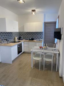 a kitchen with white cabinets and a table and chairs at Cà di GIACO in Moneglia