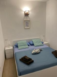 a bedroom with a bed with blue sheets and blue pillows at Cà di GIACO in Moneglia