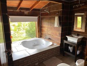 baño con bañera grande y lavamanos en Cabañas del Peñon 5 - 1 dorm en La Cumbrecita