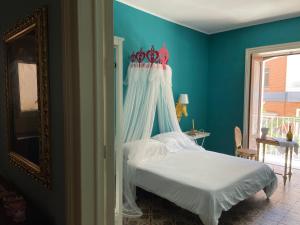 1 cama con dosel en un dormitorio azul en La Casa di Vicolo Re, Vicino alla Scala dei Turchi en Porto Empedocle