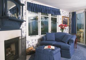 a living room with a blue couch and a fireplace at The Manor on Golden Pond in Holderness