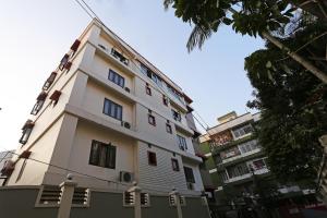 a white building with red windows on a street at Niharika Guest House in Guwahati