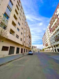 ein Auto, das auf einer Straße neben einem Gebäude geparkt ist in der Unterkunft Appart Neuf Lumineux Climatisé 1ère étage in Tangier