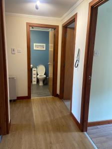 a hallway of a bathroom with a toilet at Waverley Court in Fort William