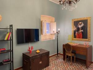 sala de estar con escritorio y TV en La Casa di Vicolo Re, Vicino alla Scala dei Turchi en Porto Empedocle