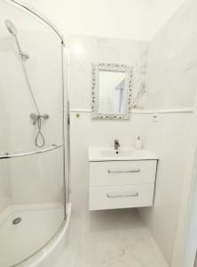 a white bathroom with a shower and a sink at White Studio in Wieliczka