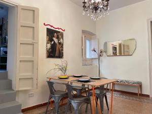 comedor con mesa, sillas y lámpara de araña en La Casa di Vicolo Re, Vicino alla Scala dei Turchi en Porto Empedocle