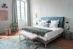 a bedroom with a large bed and a pink stool at Domaine de Chalamon - Fontenille Collection in Saint-Rémy-de-Provence