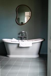 a bath tub in a bathroom with a mirror at Domaine de Chalamon in Saint-Rémy-de-Provence