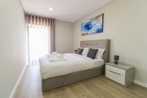 een slaapkamer met een groot bed en een raam bij Sunshine Apartment - Modern Ap Near the Beach in Viana do Castelo