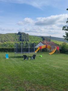 a park with a playground with two chairs and a slide at Chalet, aux portes du Morvan in Voudenay-lʼEglise