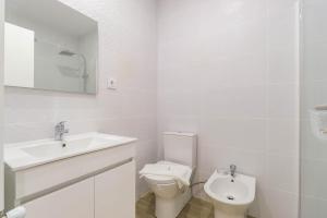um banheiro branco com um vaso sanitário e uma pia em Sunshine Apartment - Modern Ap Near the Beach em Viana do Castelo