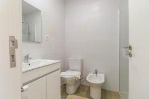 a white bathroom with a toilet and a sink at Sunshine Apartment - Modern Ap Near the Beach in Viana do Castelo