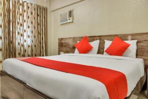 sypialnia z dużym łóżkiem z czerwonymi poduszkami w obiekcie OYO Rana Residency Near Western Express Highway Metro Station w Bombaju