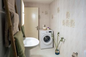 a bathroom with a washing machine and a washer at Giotas House in Poros