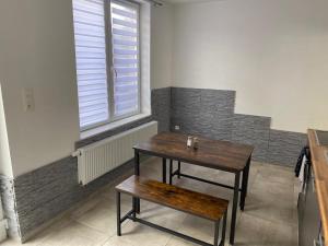 a table and a bench in a room with a window at Maison proche du centre ville de la gare l aéroport de Charleroi in Charleroi